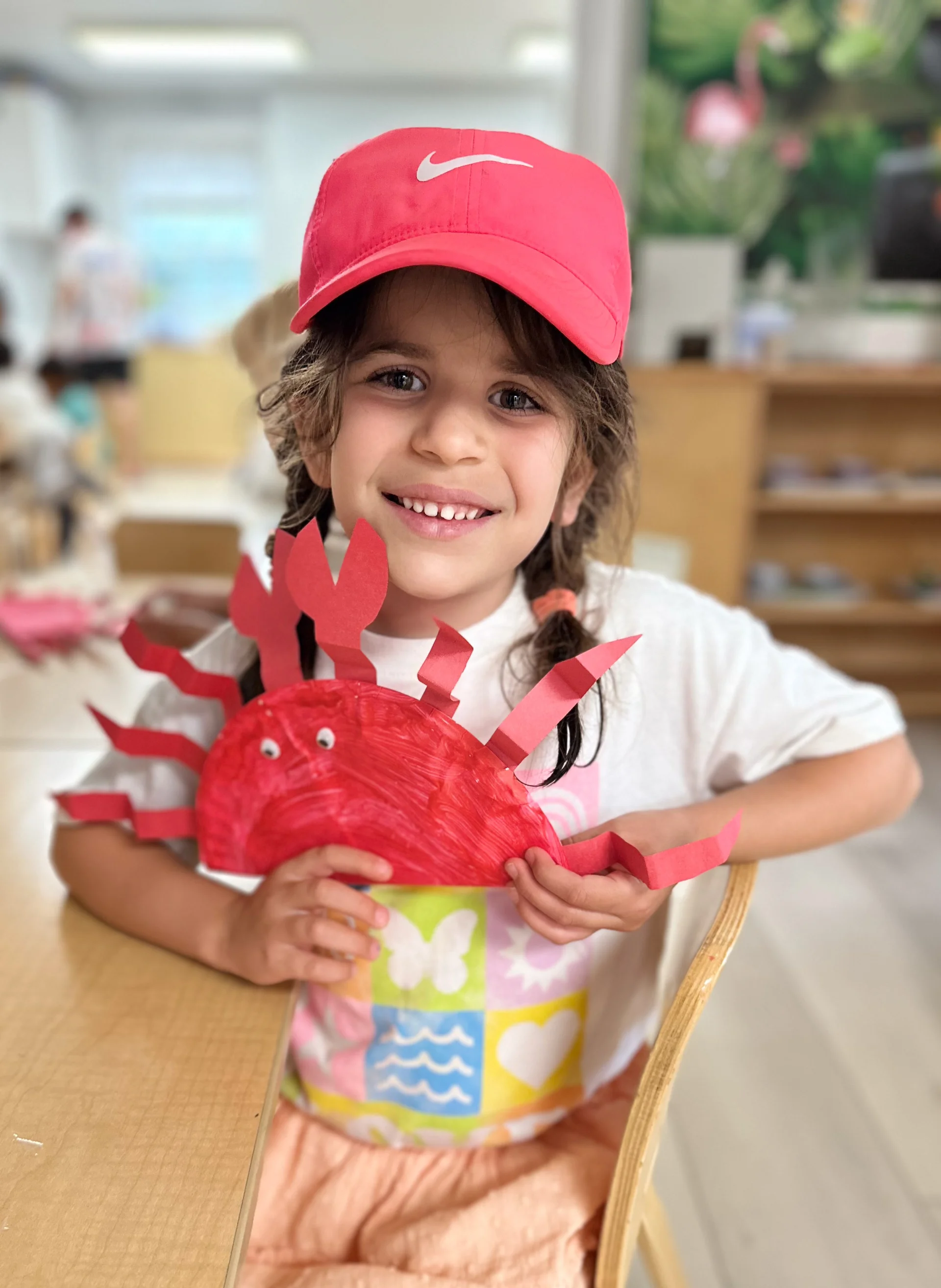 grade schooler showing their art from their summer camp